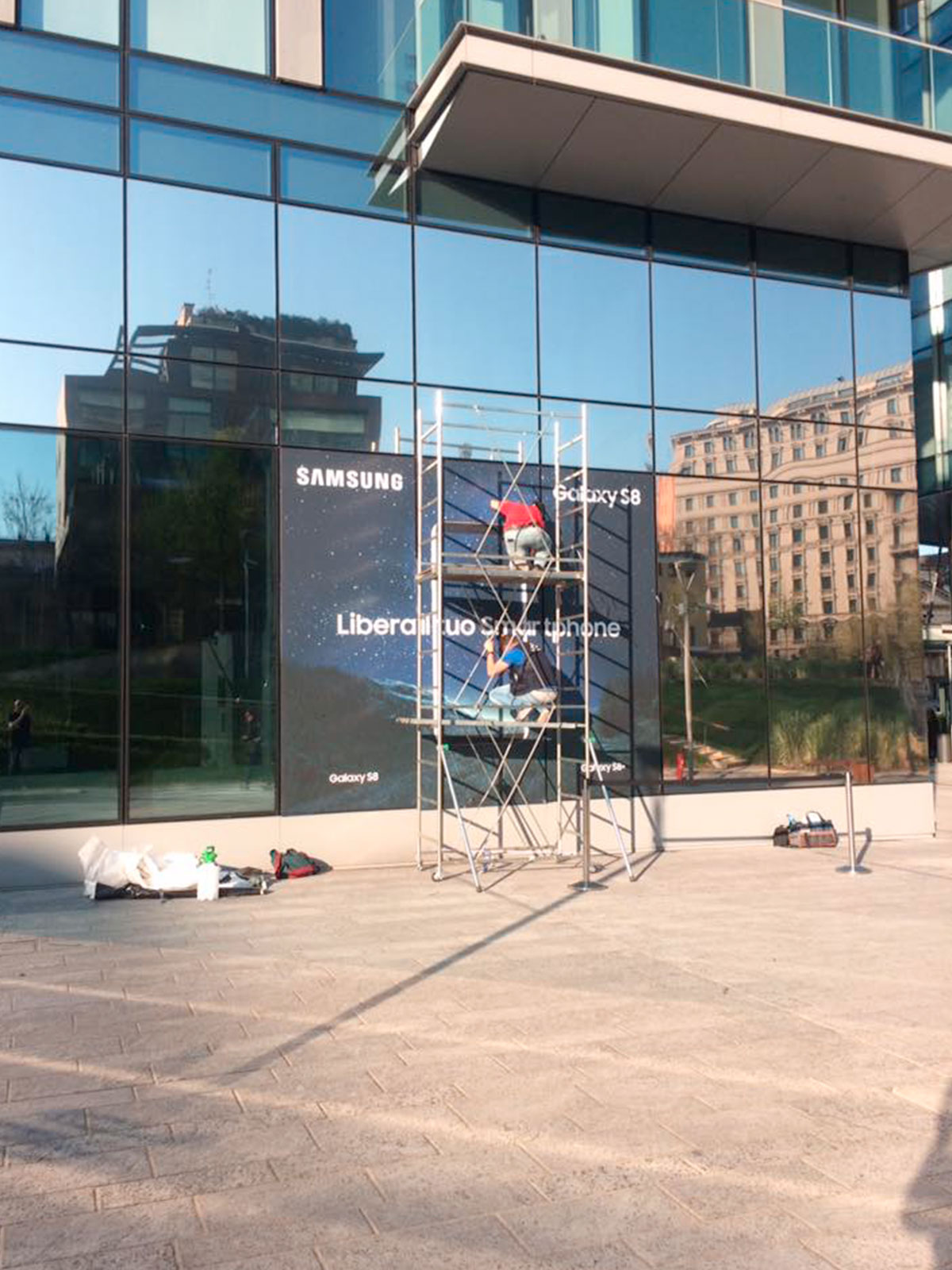 Fase di applicazione di pellicola decorativa adesiva su vetrate Samsung District, Facility Service Milano